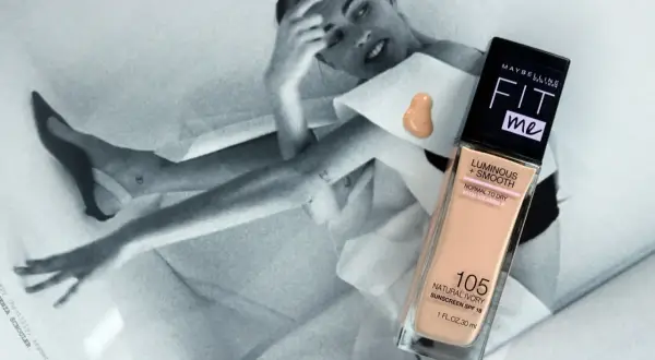 Maybelline Fit Me podkład rozświetlający w odcieniu 105 Natural Ivory na tle czarno-białej sesji zdjęciowej.