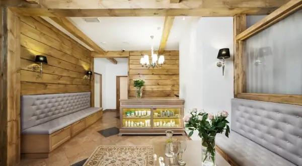 Przytulne wnętrze salonu spa w Białymstoku i okolicach. Drewniane ściany, wygodne ławy i ekspozycja kosmetyków tworzą atmosferę relaksu.